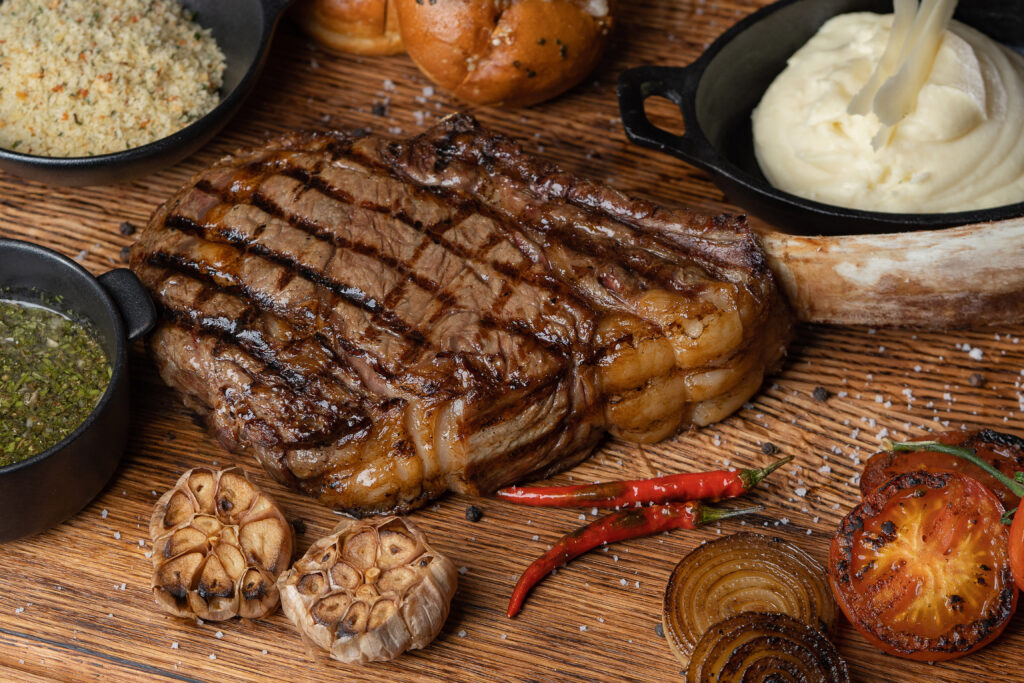 Grilled Tomahawk steak served with mashed potatoes, roasted garlic, and grilled vegetables at Sapphire Plaza Hotel Doha
